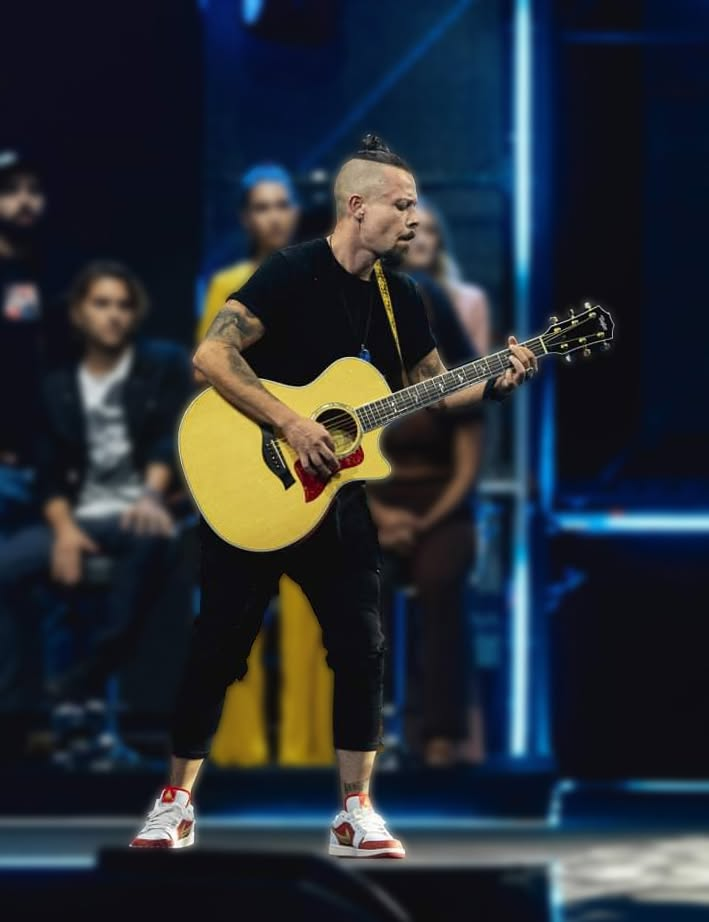 Glenn Sacco performing live on stage with an acoustic guitar
